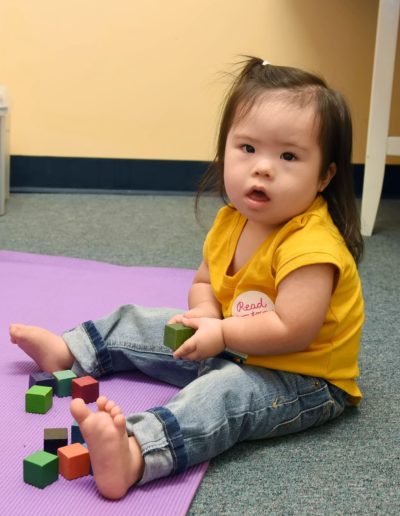 Young girl playing with blocks at Sumlar Therapy Services, Inc