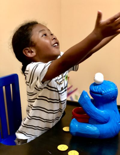 Girl playing with cookie monster toy at Sumlar Therapy Services, Inc
