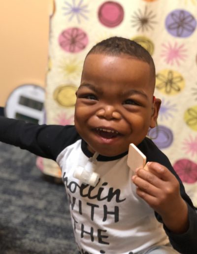 Young baby laughing at a block