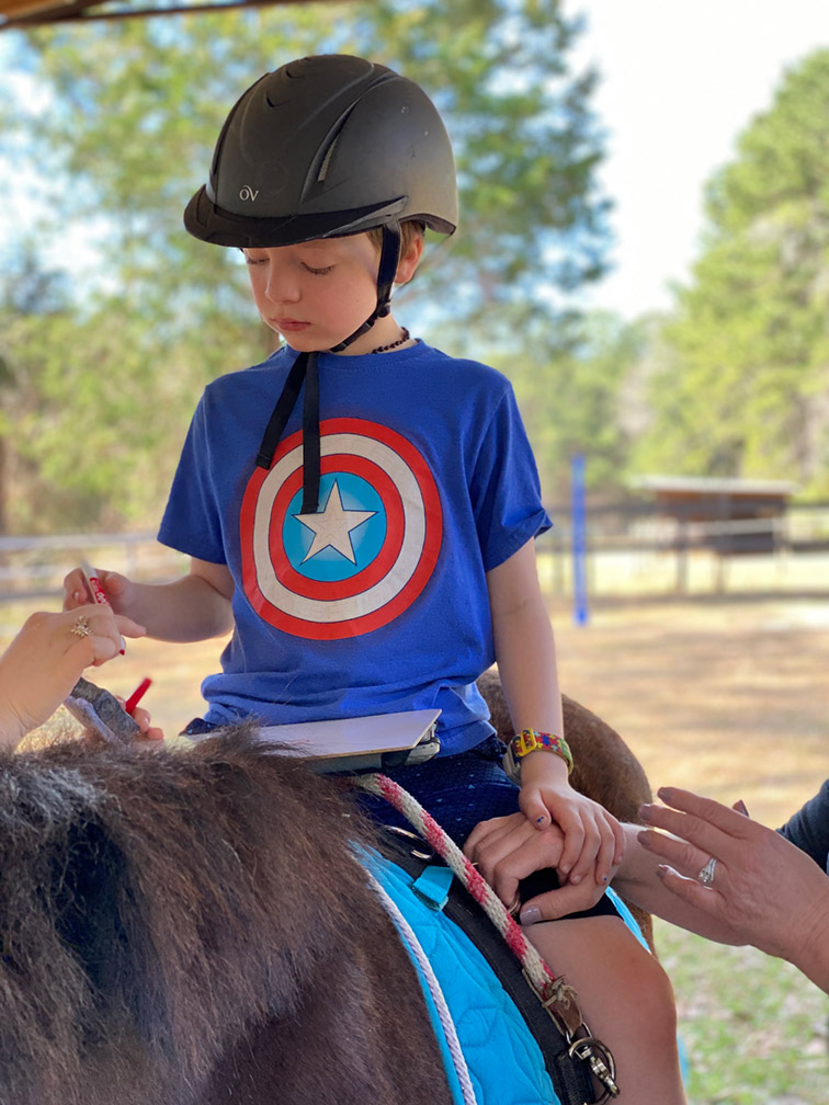 Boy riding a horse at Sumlar Therapy Services, Inc