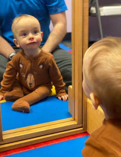 Infant looking at a mirror at Sumlar Therapy Services, Inc